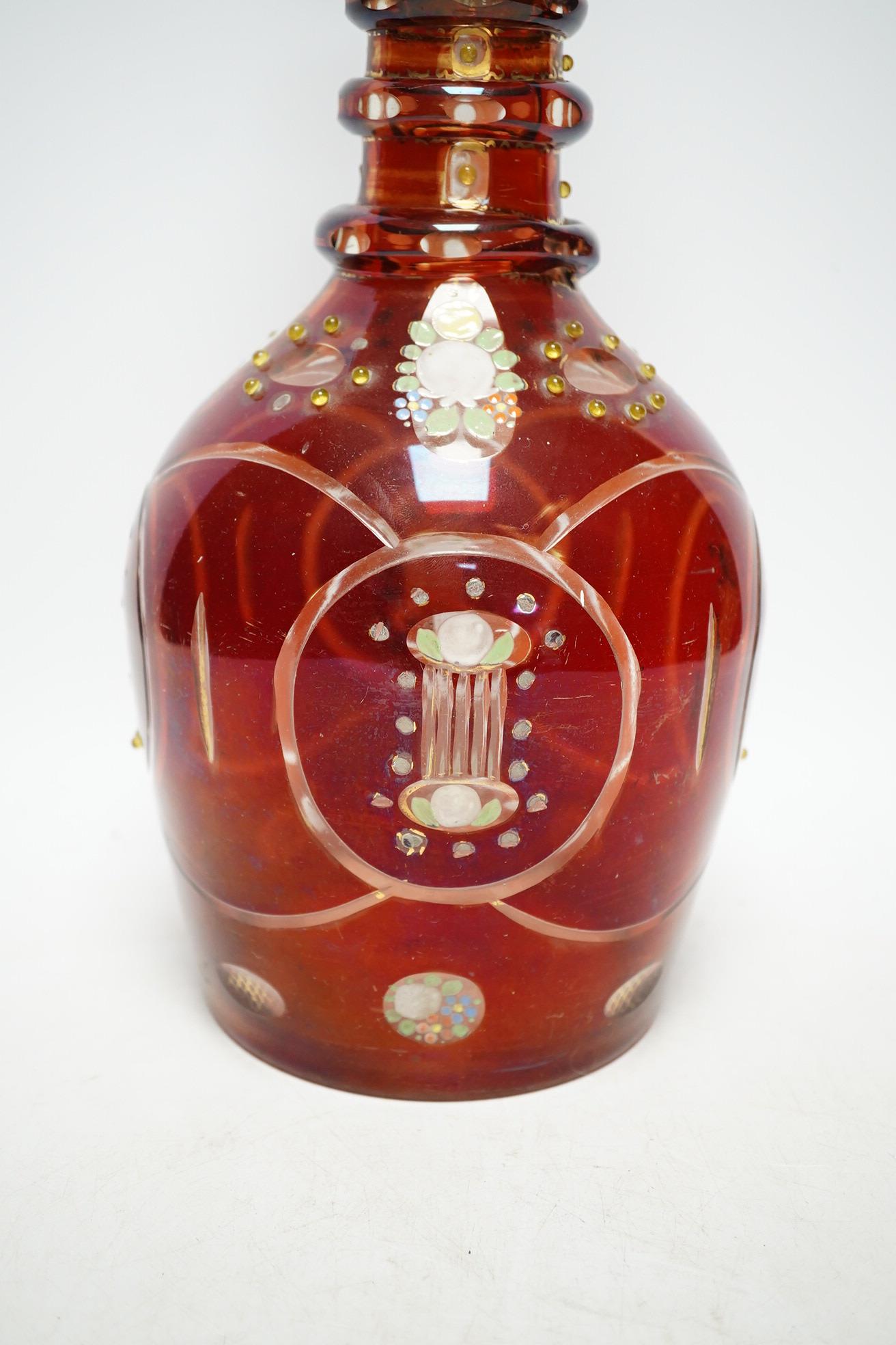 An early 20th century Bohemian overlaid and painted ruby glass decanter, 51cm. Condition - fair